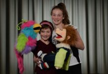 Youth choir pulling strings to stage fist puppet show